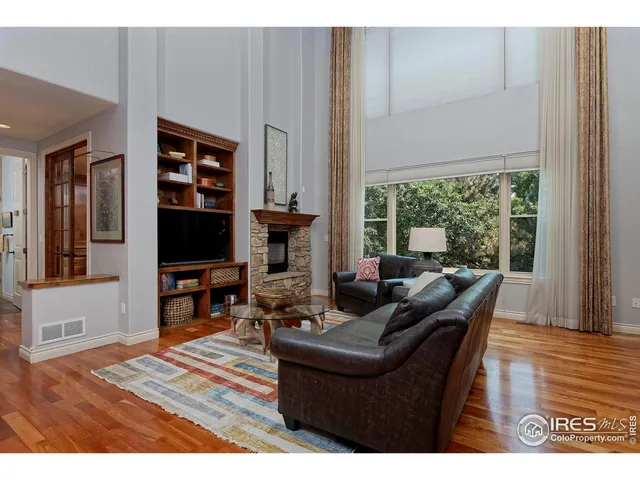 a living room with furniture a flat screen tv and a floor to ceiling window