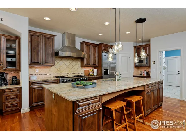 a kitchen with kitchen island granite countertop wooden cabinets and a sink