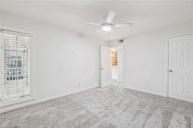 an empty room with closet and ceiling fan
