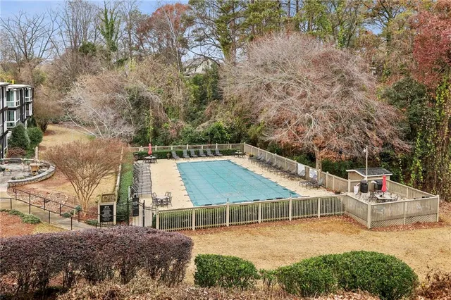 a sign board with a house and trees in the background