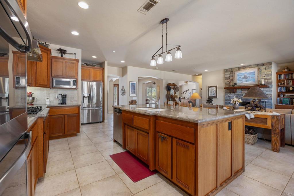 10204 Mt Olympus Valley Road Fallbrook, CA 92028 - Photo 18 of 59 a kitchen with stainless steel appliances granite countertop a sink counter space cabinets and a counter top space