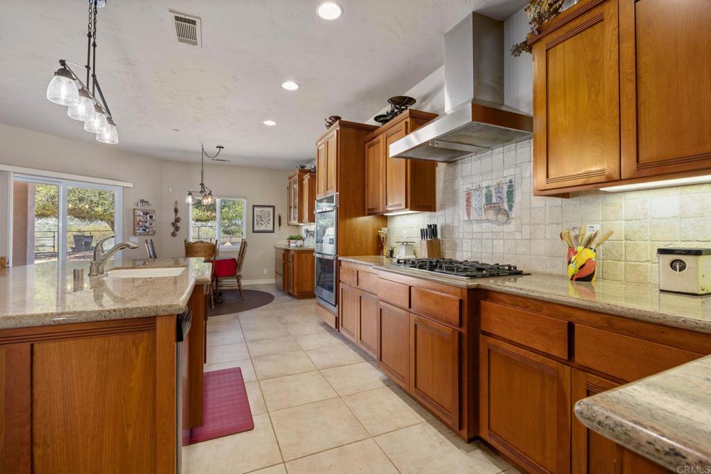 10204 Mt Olympus Valley Road Fallbrook, CA 92028 - Photo 19 of 59 a kitchen with granite countertop cabinets stainless steel appliances a sink and a window