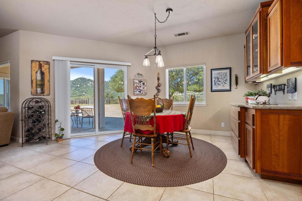 10204 Mt Olympus Valley Road Fallbrook, CA 92028 - Photo 20 of 59 a dining room with furniture a chandelier and window
