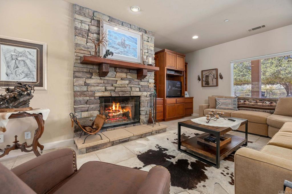 10204 Mt Olympus Valley Road Fallbrook, CA 92028 - Photo 25 of 59 a living room with furniture a large window and a fireplace