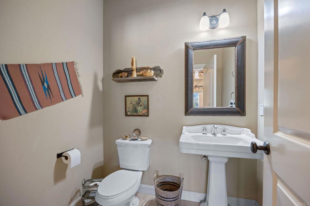 10204 Mt Olympus Valley Road Fallbrook, CA 92028 - Photo 26 of 59 a bathroom with a toilet a sink and mirror