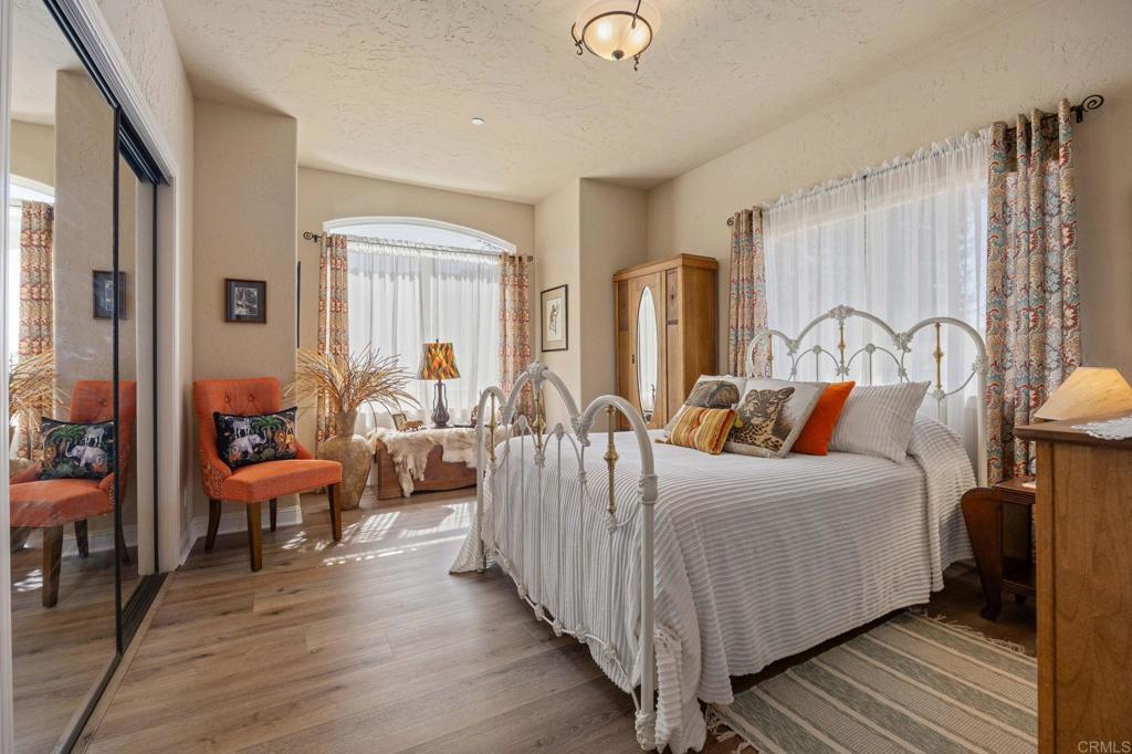 10204 Mt Olympus Valley Road Fallbrook, CA 92028 - Photo 35 of 59 a spacious bedroom with a bed and wooden floor