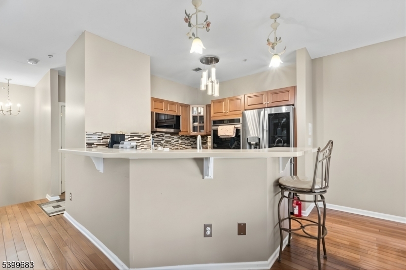 159 George Russell Way Clifton, NJ 07013 - Photo 10 of 25 a kitchen with stainless steel appliances kitchen island granite countertop a table chairs and a refrigerator