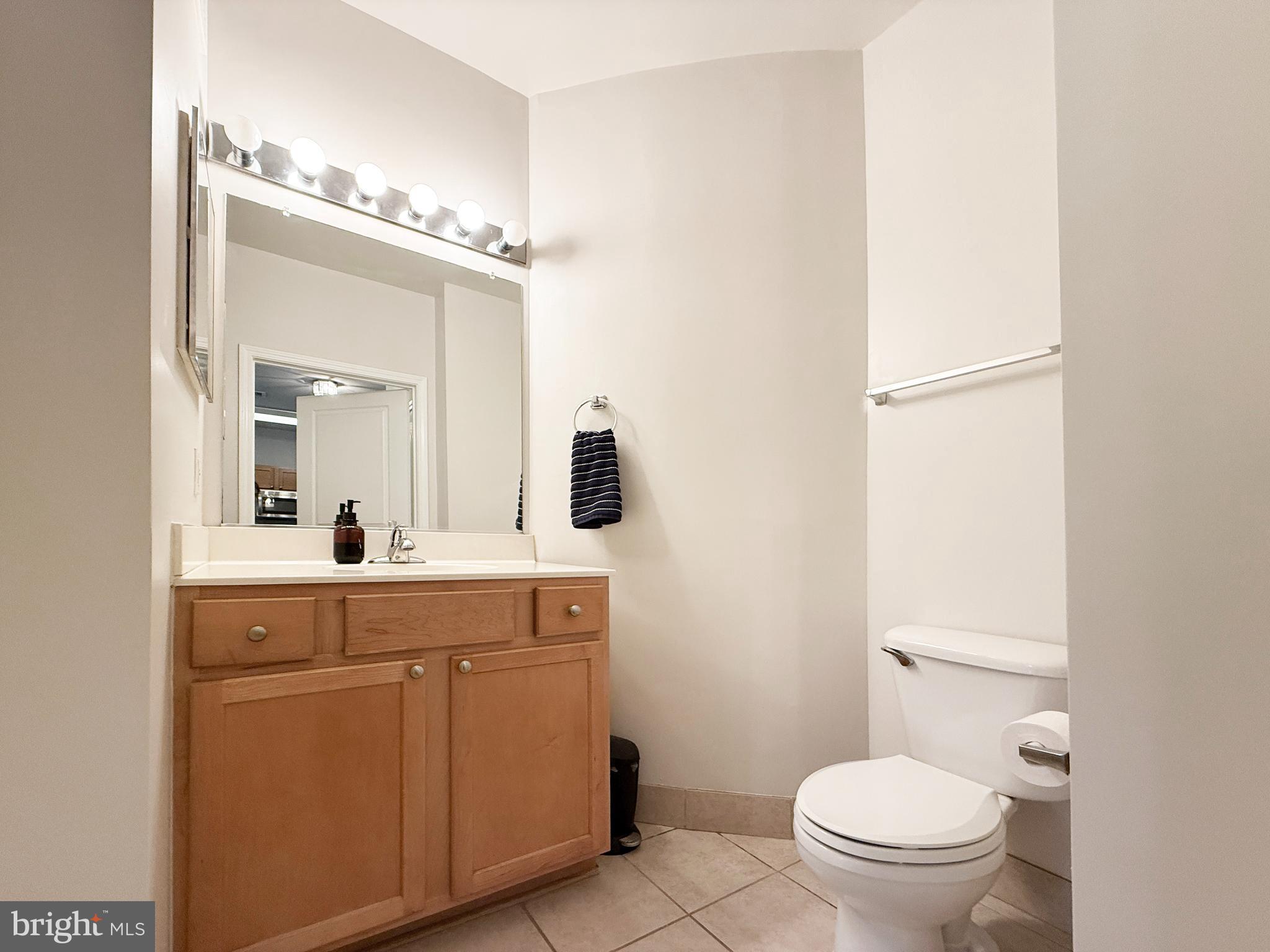 12000 Market Street, Unit 175 Reston, VA 20190 - Photo 10 of 27 a spacious bathroom with a toilet a sink a mirror and vanity