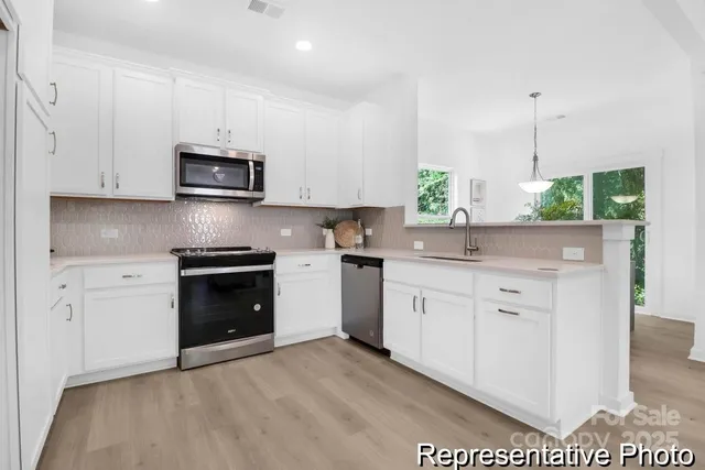 a kitchen with stainless steel appliances a stove a sink and a microwave