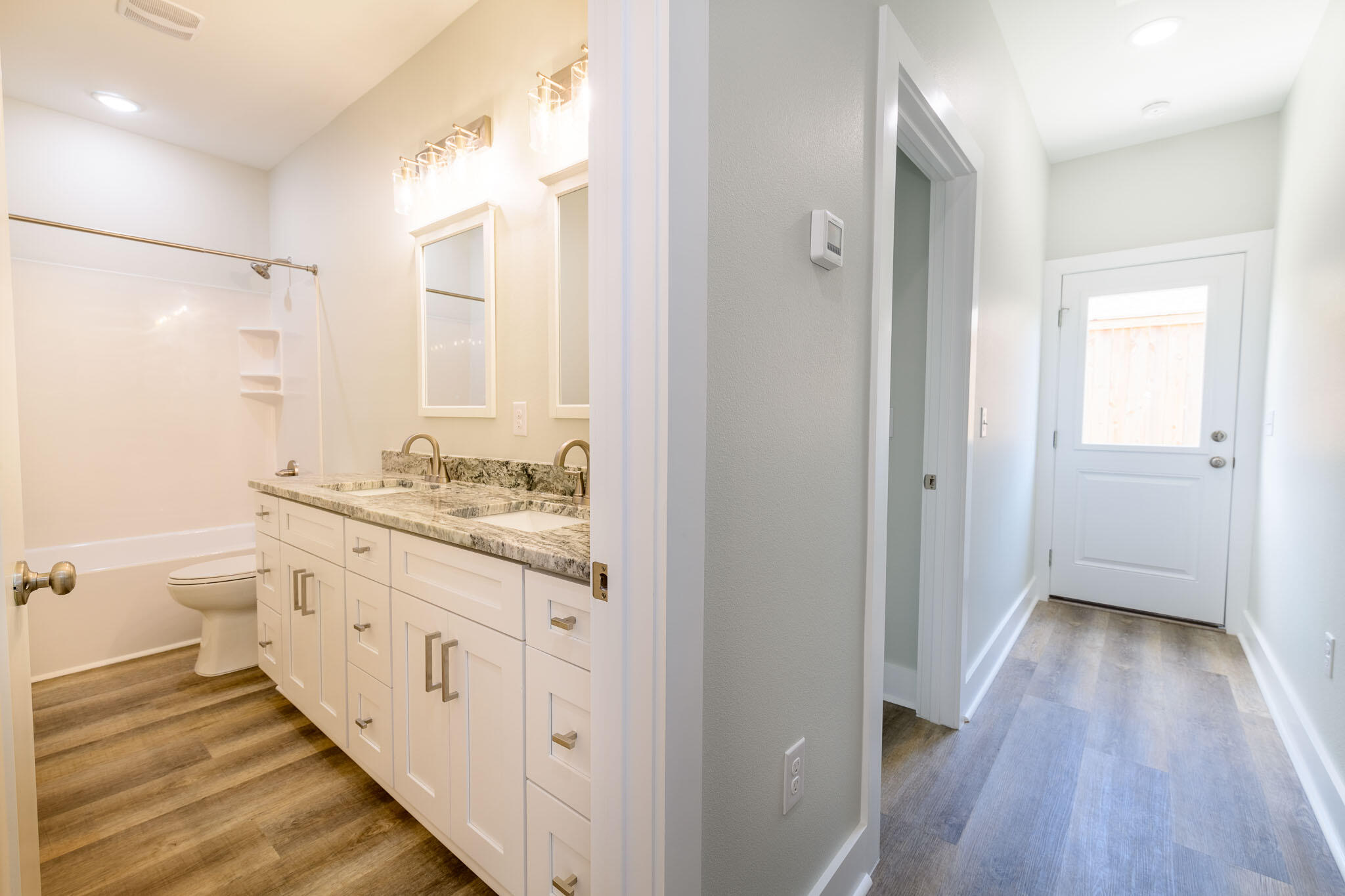 107 Clearing Way Valparaiso, FL 32580 - Photo 12 of 22 a bathroom with a granite countertop double vanity sink a mirror and a shower
