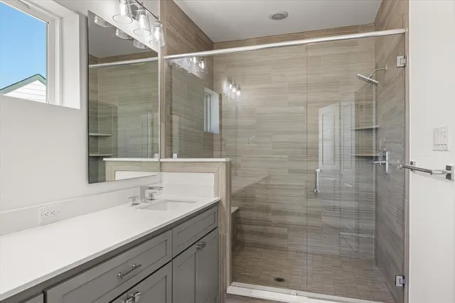a bathroom with a shower sink and mirror