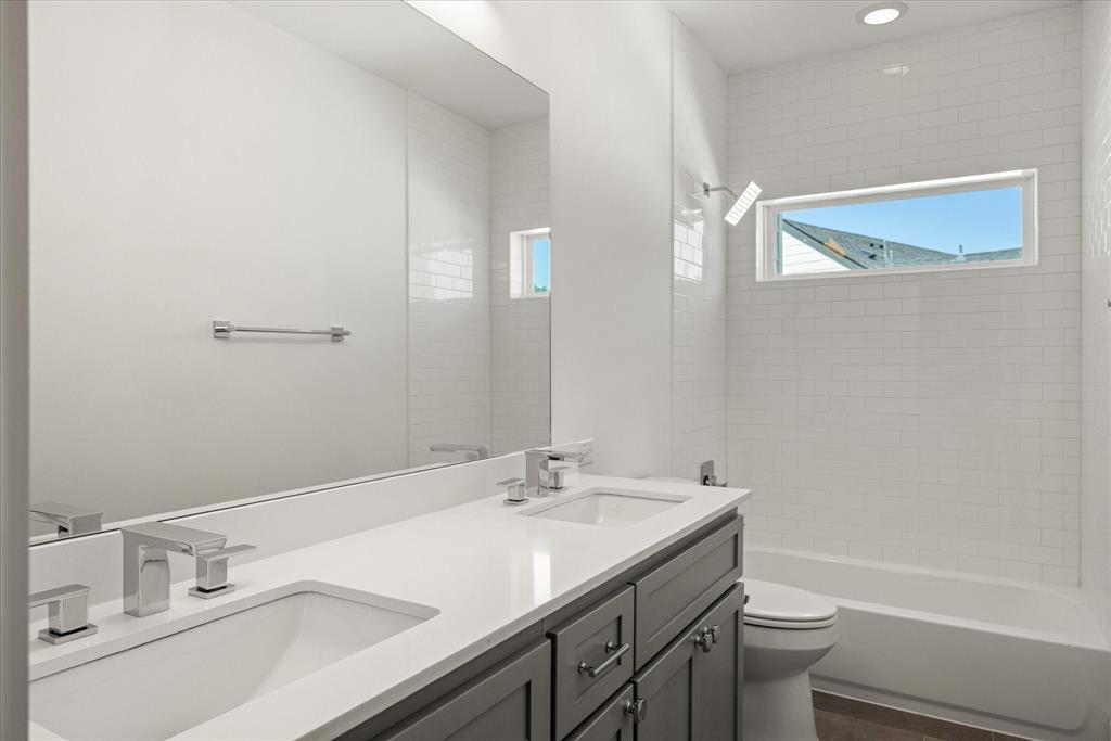 2125 Bird Street Fort Worth, TX 76111 - Photo 21 of 34 a bathroom with a granite countertop sink a toilet and shower