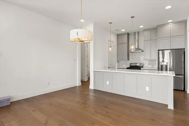 a large kitchen with granite countertop a white refrigerator a oven a sink and white cabinets