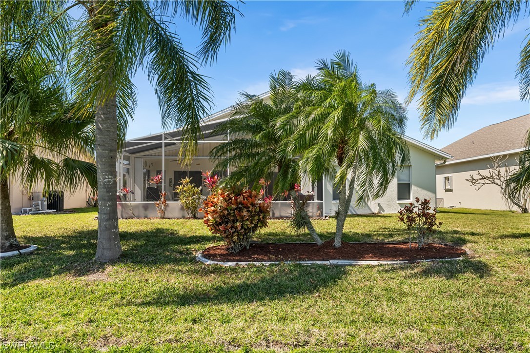 17536 Plumera Lane North Fort Myers, FL 33917 - Photo 37 of 50 a view of a house with a yard and palm trees