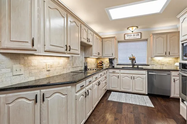 a kitchen with granite countertop white cabinets and white appliances