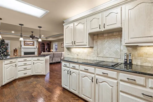 a kitchen with granite countertop white cabinets and white appliances
