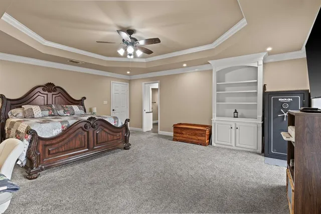 a spacious bedroom with a bed and a chandelier