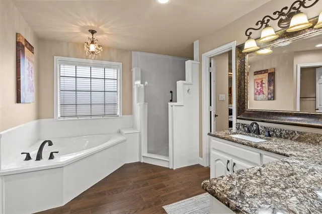 a bathroom with a tub sink and mirror