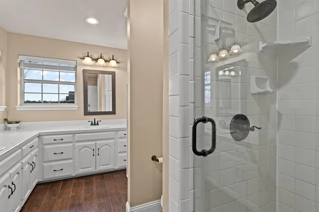 a bathroom with a double vanity sink mirror and shower