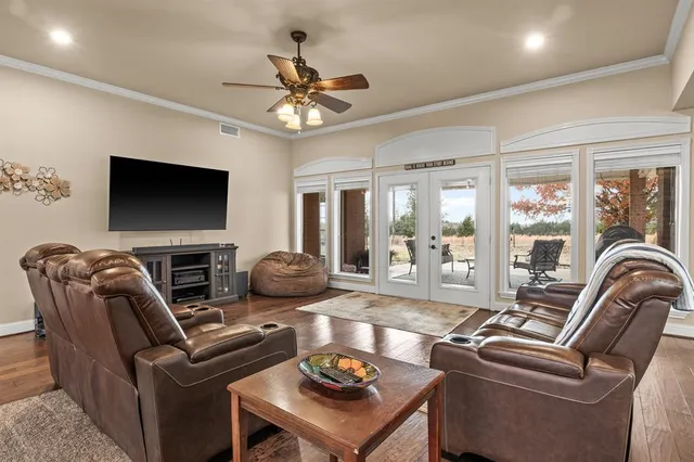 a living room with furniture a flat screen tv and a large window