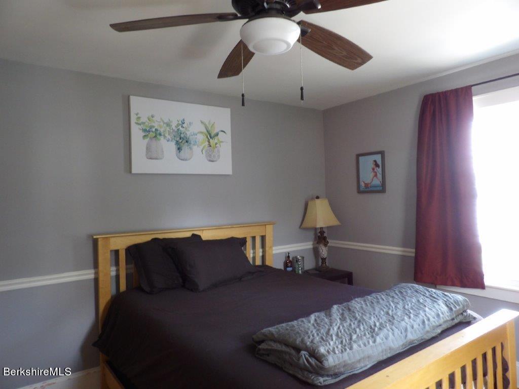 64 Cleveland Street Pittsfield, MA 01201 - Photo 17 of 32 a bedroom with a bed and wooden floor