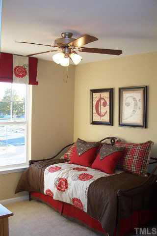 3637 Bison Hill Lane Raleigh, NC 27604 - Photo 6 of 10 a bedroom with a large bed and a chandelier