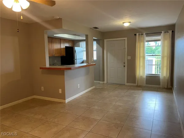 a view of an empty room with window and wooden floor