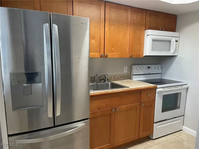 a kitchen with a refrigerator sink and cabinets