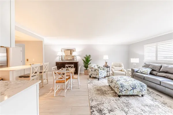 a living room with furniture and view of kitchen