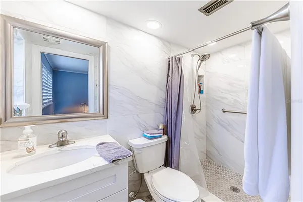 a bathroom with a sink vanity mirror and toilet