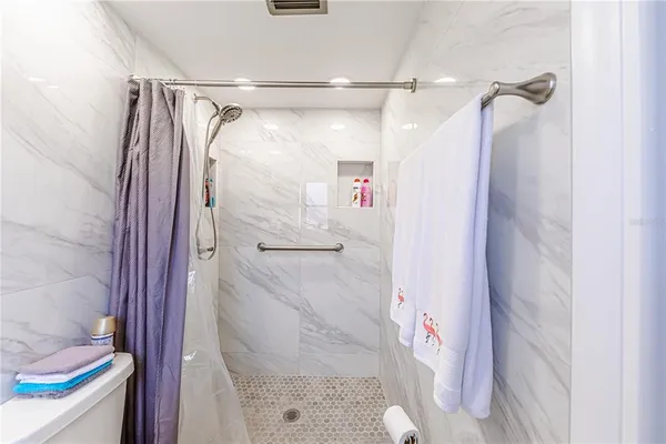 a bathroom with a shower and a glass door
