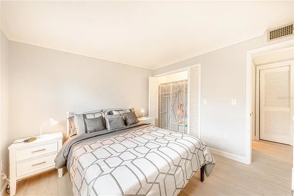 a bedroom with a bed and wooden floor