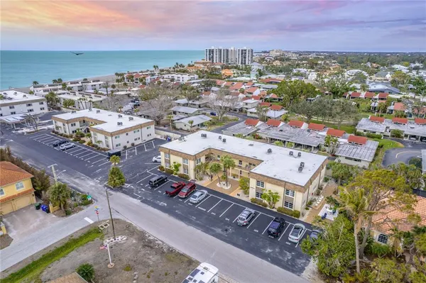 an aerial view of a city with lots of residential buildings ocean and mountain view in back