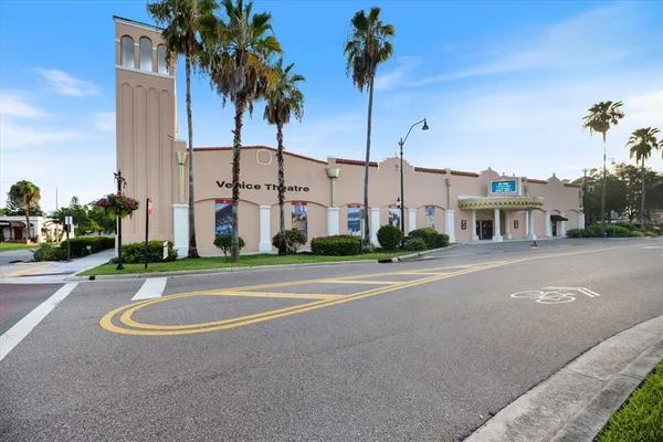 a view of a tall white building next to a yard