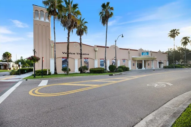 a view of a tall white building next to a yard
