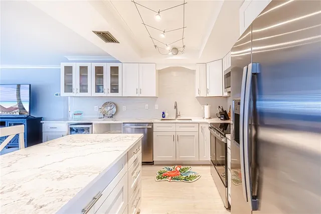 a kitchen with a sink refrigerator and cabinets