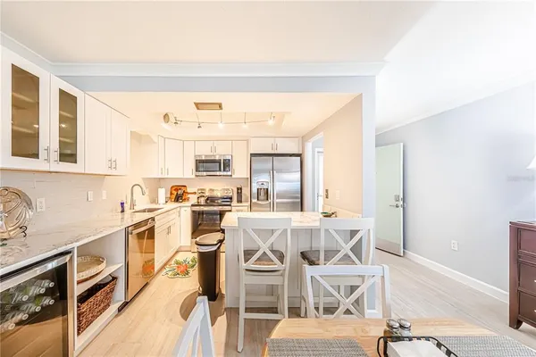 a view of a kitchen with wooden floor and stainless steel appliances