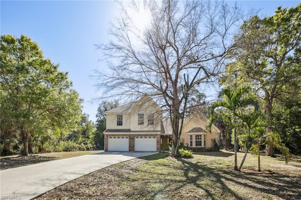 5348 Cypress Lane Naples, FL 34113 - Photo 2 of 28 a front view of a house with a yard