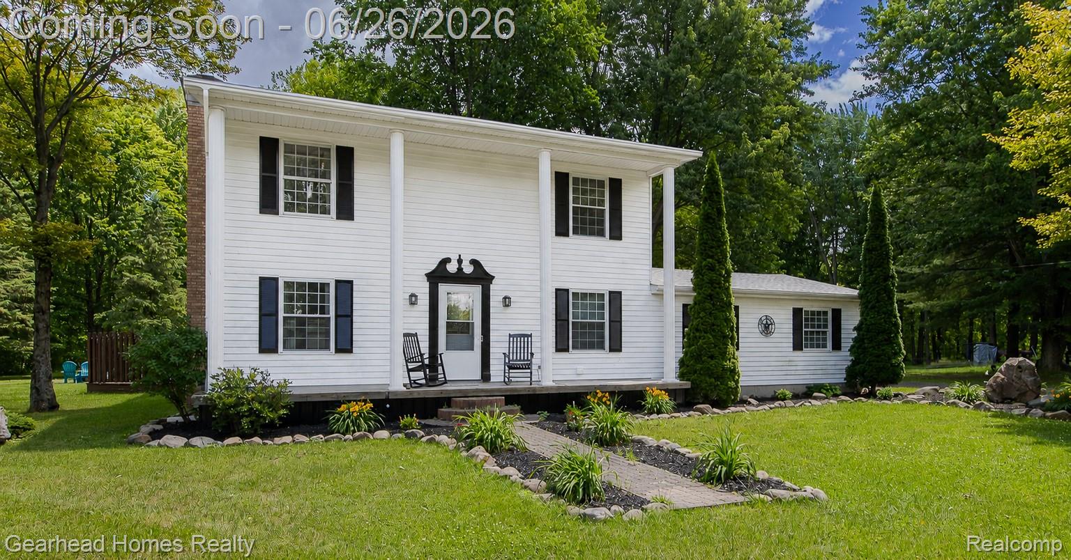 Two-story white siding exterior with a welcoming porch and classical pillars