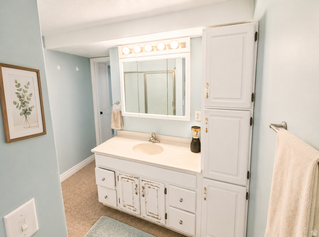 1020 Wilmar Place Centerville, UT 84014 - Photo 16 of 22 Bathroom featuring a white vanity with integrated sink, a medicine cabinet with mirror and overhead lighting, and a tall built-in storage cabinet