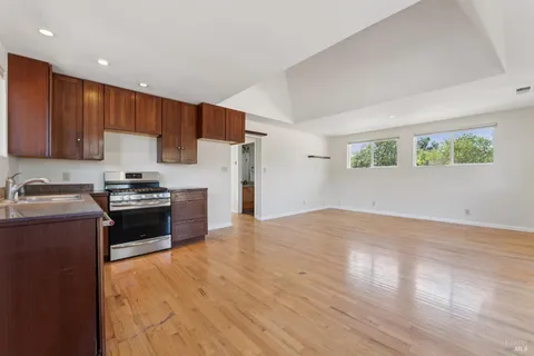 a kitchen with granite countertop a refrigerator stove top oven and sink