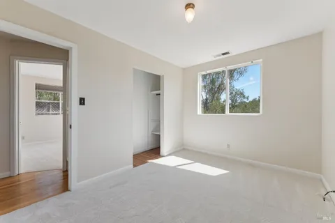 an empty room with windows and closet