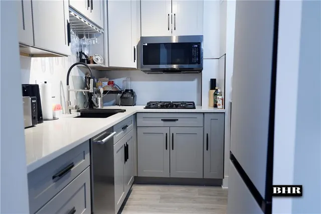 a kitchen with stainless steel appliances granite countertop a sink stove and microwave