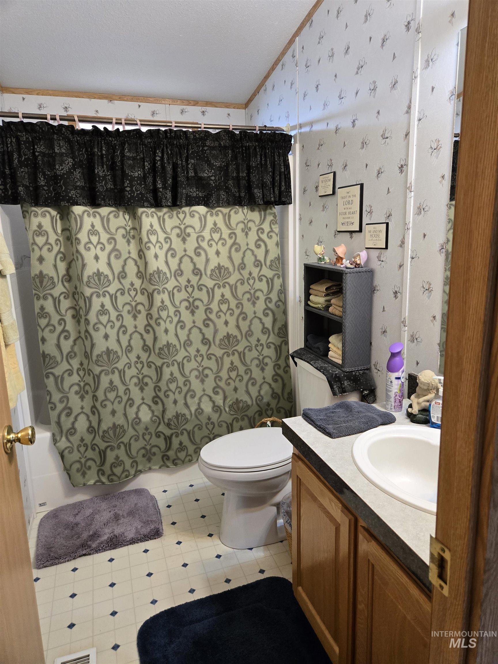 2750 Alden Road, Unit 37 Fruitland, ID 83619 - Photo 23 of 30 Bathroom featuring wallpapered walls, vanity, lofted ceiling, shower / tub combo with curtain, and ornamental molding
