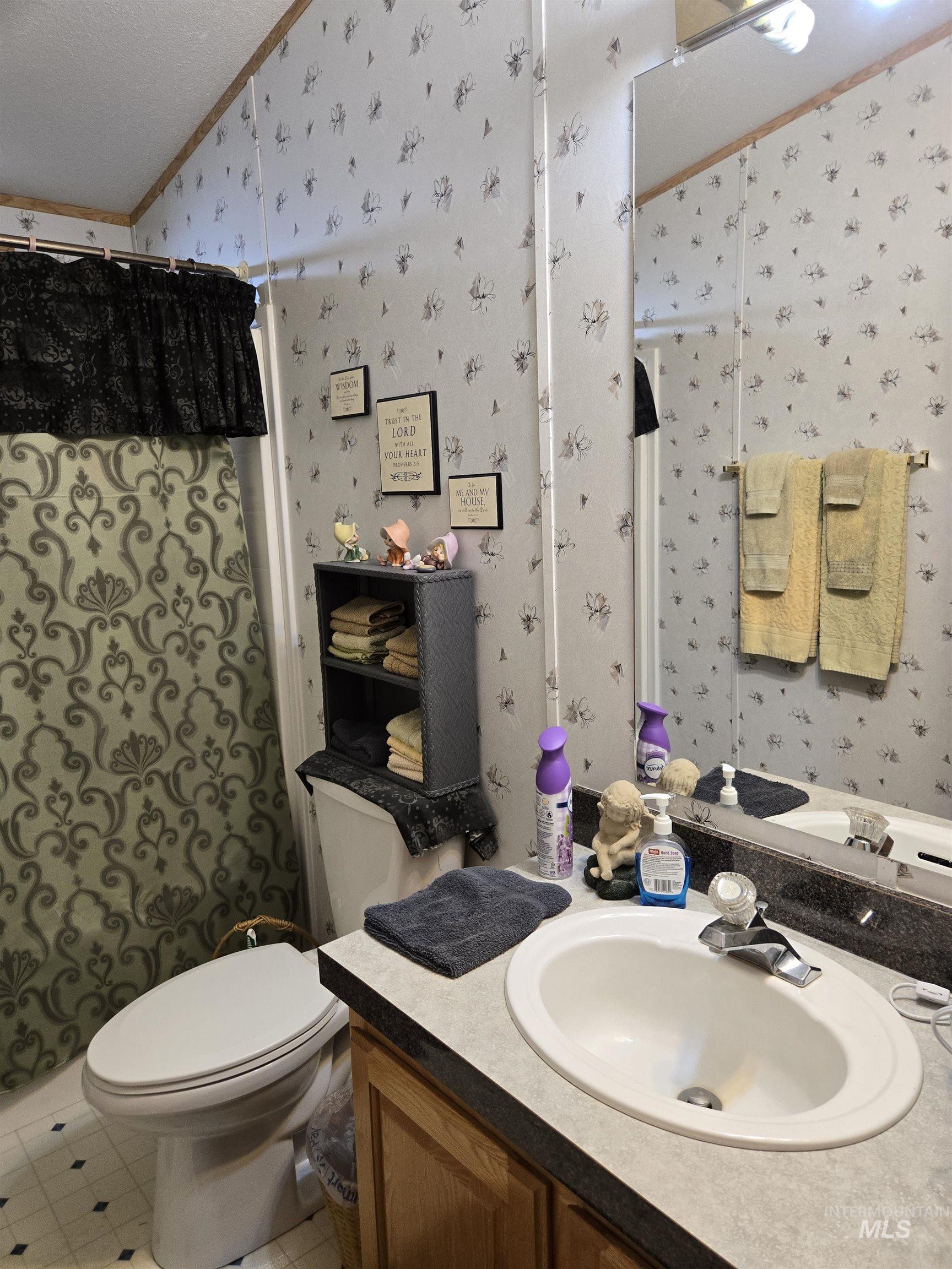 2750 Alden Road, Unit 37 Fruitland, ID 83619 - Photo 24 of 30 Bathroom featuring wallpapered walls, crown molding, vanity, a shower with shower curtain, and lofted ceiling