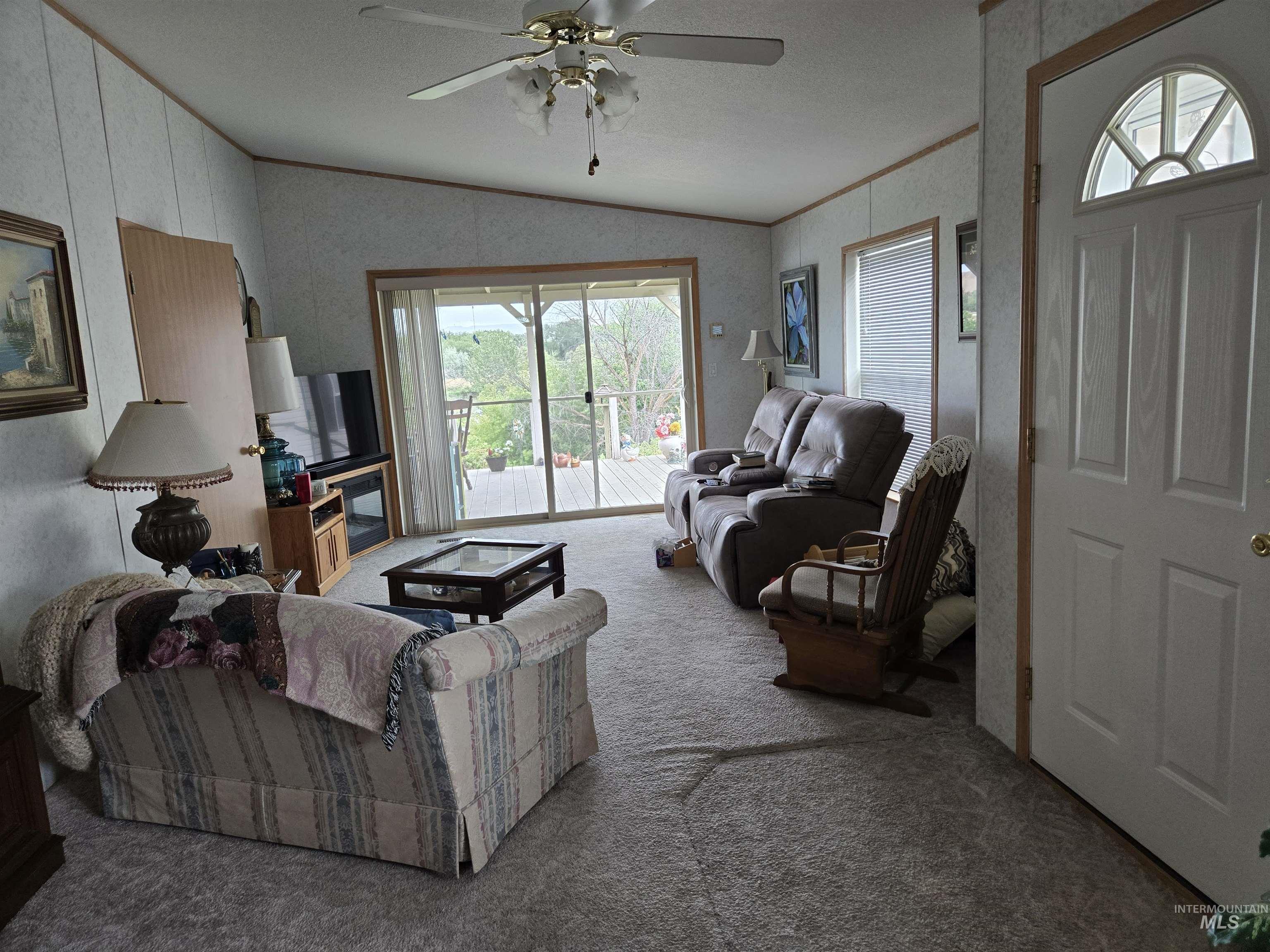 2750 Alden Road, Unit 37 Fruitland, ID 83619 - Photo 8 of 30 Carpeted living room featuring lofted ceiling, ceiling fan, and ornamental molding