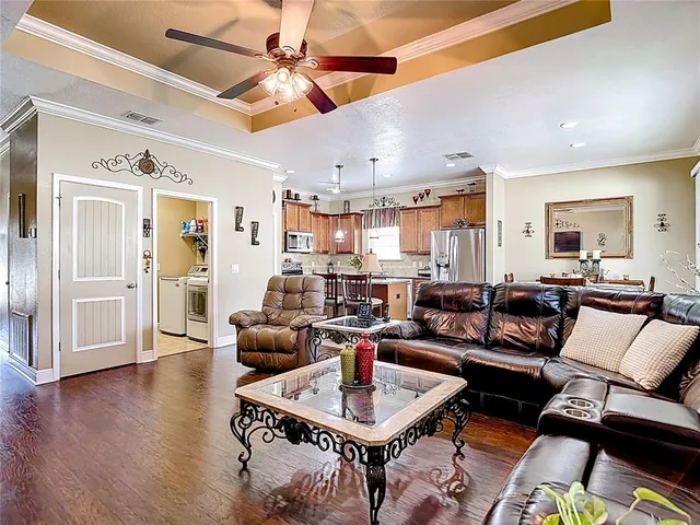 a kitchen with stainless steel appliances granite countertop a refrigerator a sink dishwasher a stove and a refrigerator with wooden floor