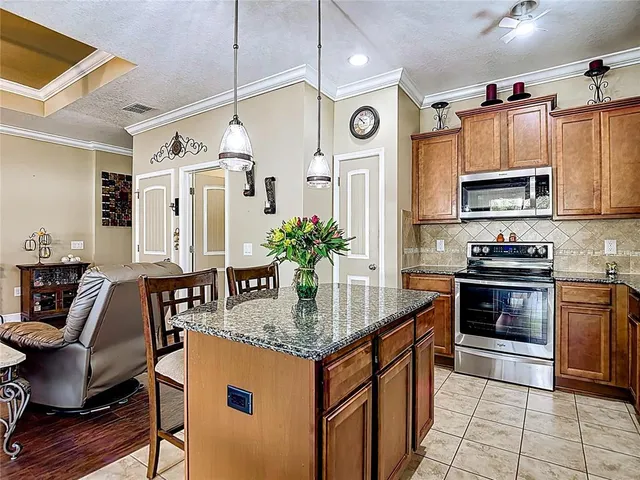 a kitchen with stainless steel appliances granite countertop a sink a stove and a microwave