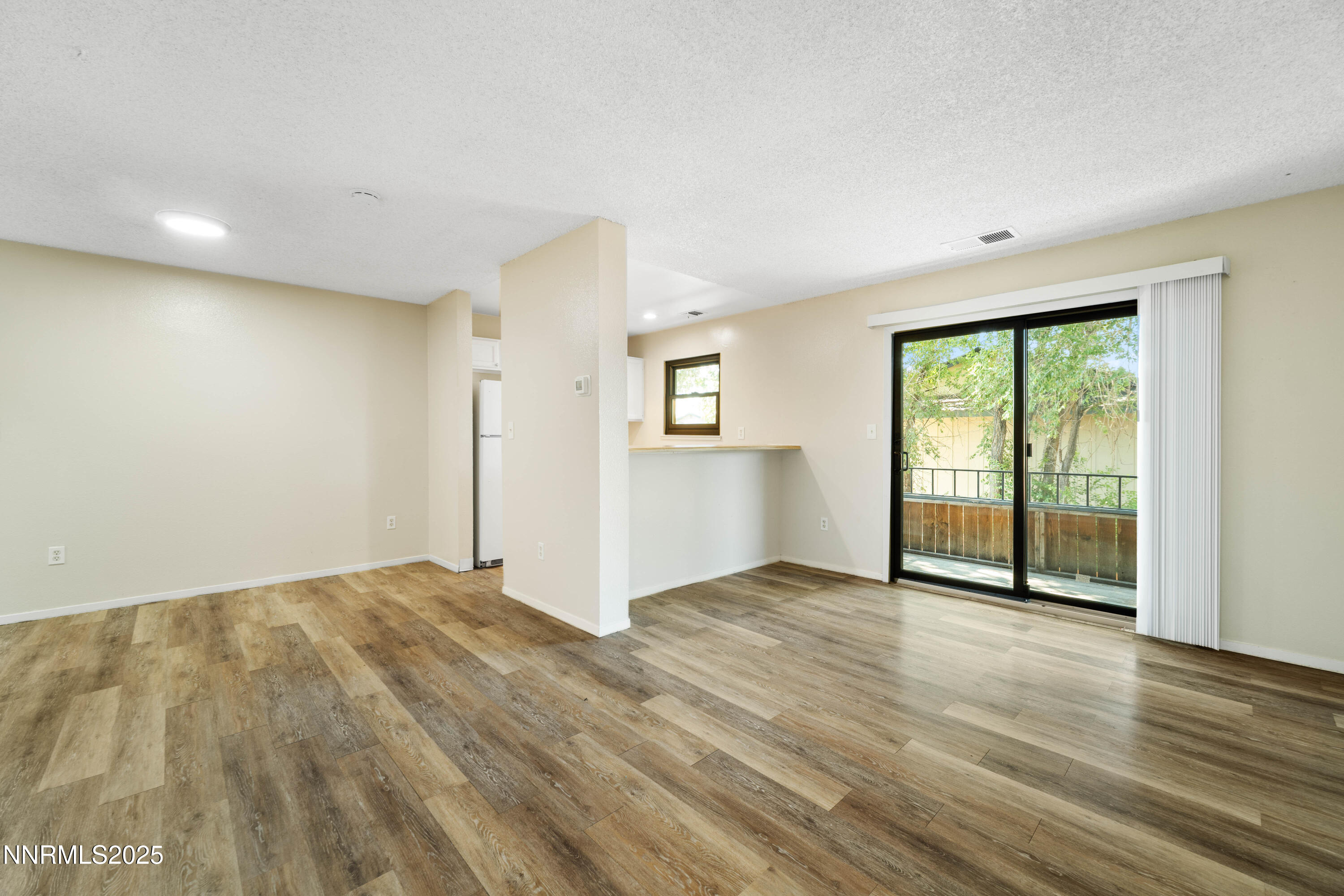 2229 Kietzke Lane, Unit G Reno, NV 89502 - Photo 3 of 9 an empty room with wooden floor and windows