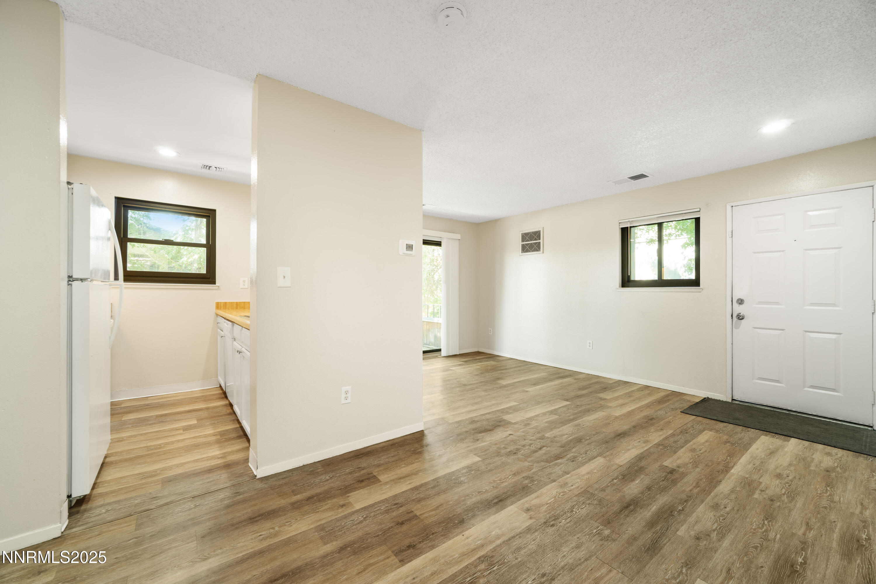 2229 Kietzke Lane, Unit G Reno, NV 89502 - Photo 5 of 9 an empty room with wooden floor and windows